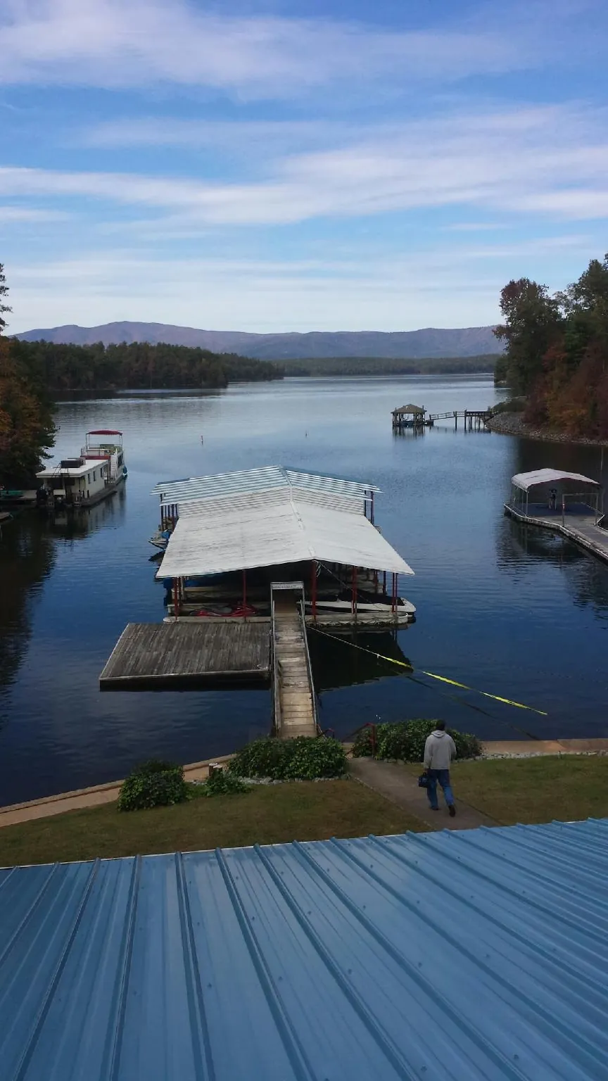View across a lake from a newly installed blue metal roof in Springville